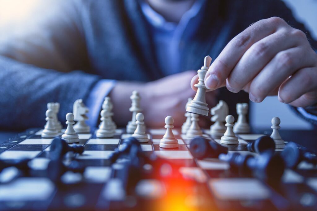 pexels-photo-1040157 Close-up of a hand making a strategic chess move on a board, emphasizing thought and planning.
